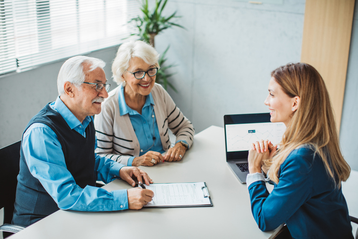 A senior couple meeting with an advisor before they claim retirement benefits.